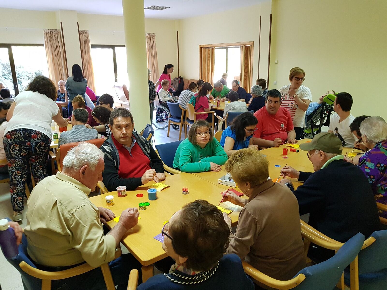 Grupo de personas voluntarias de ADECAS con camisetas azules